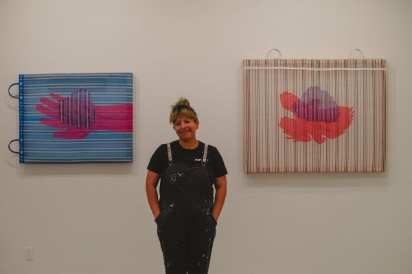 Dulce Soledad Ibarra standing with their artwork at the MSJC art gallery