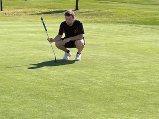 Eyes on the line, Shane Agundez steadies over the putt, rolling it across the green with a chance to finish the hole in style.